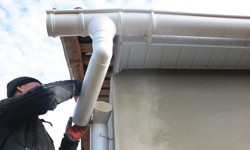Guttering professional fixing downpipe and guttering to house